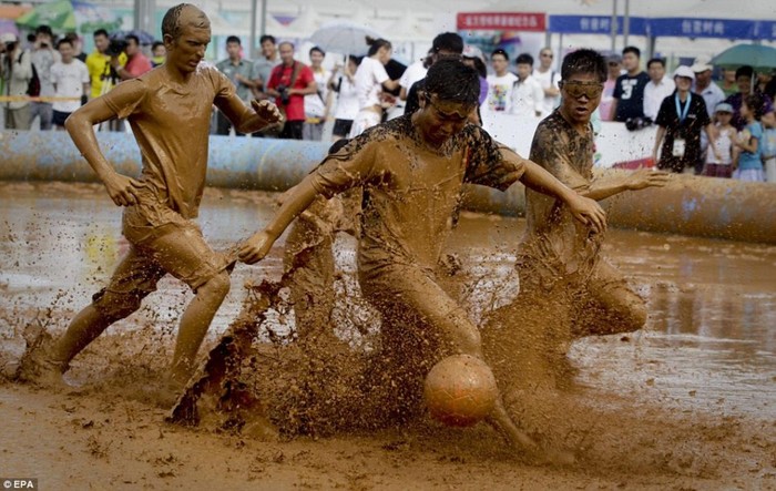 Các cầu thủ thi đấu bên ngoài SVĐ Tổ Chim, Bắc Kinh, Trung Quốc tại giải Bóng đá sân bùn.